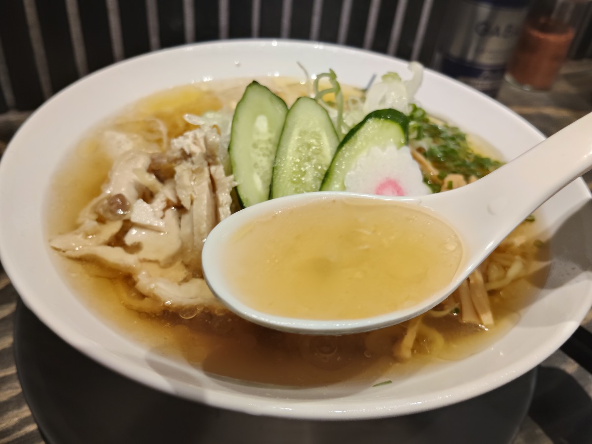 レンゲですくう澄んだ鶏スープ